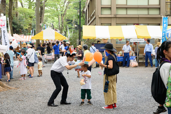 府中市の広報課の方がお子さんに風船を配布しているところ